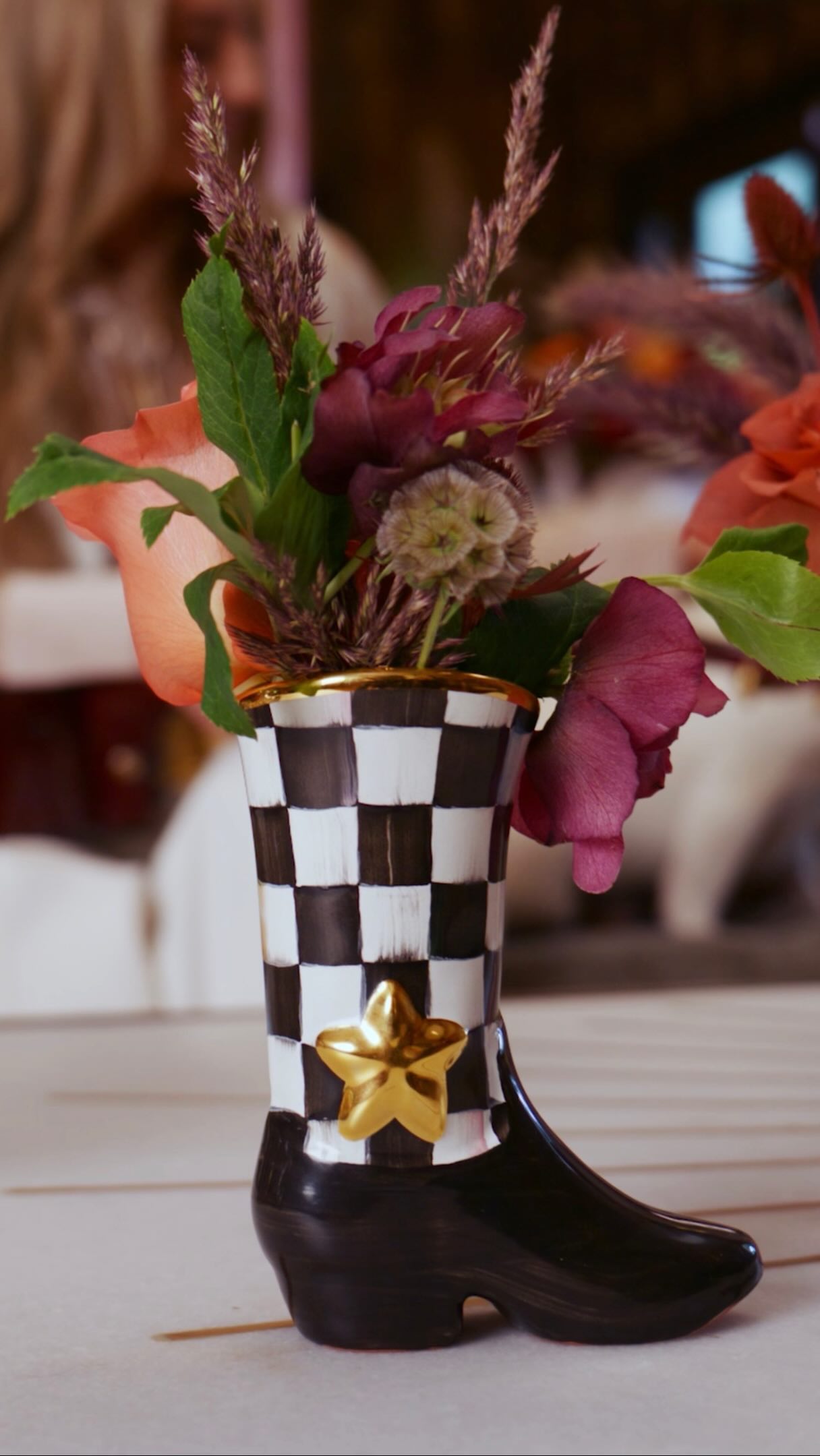 Flowers in a patterned cowboy-boot vase from the Lainey Wilson and MacKenzie-Childs collection